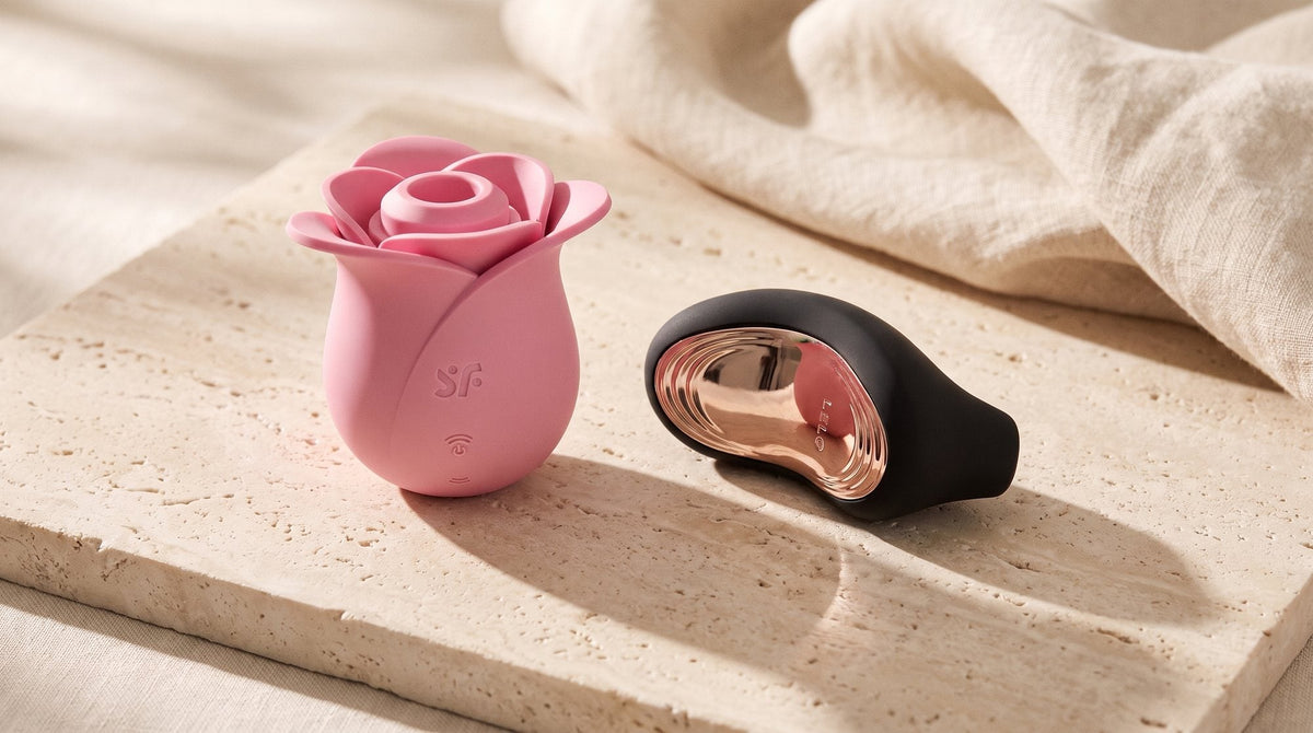 Stimulateur Satisfyer Pro 2 Modern Blossom rose et LELO Sona 2 Cruise posés côte à côte sur une dalle de pierre claire