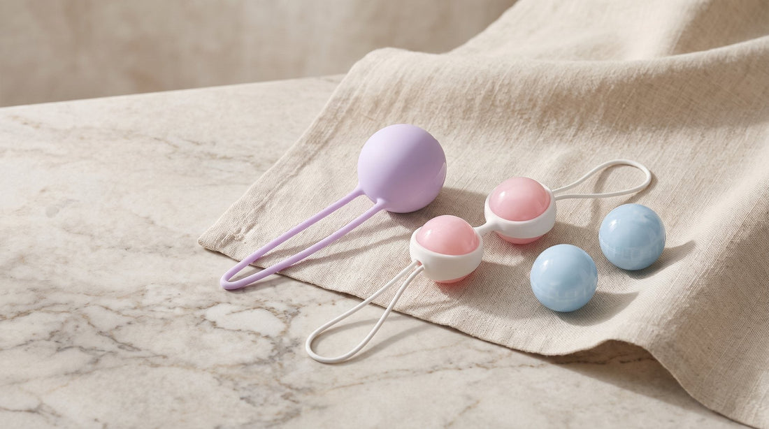 Bola FUN FACTORY Smartball Uno y dos bolas LELO Luna Beads Mini junto a su soporte de silicona, sobre lino crudo y piedra clara