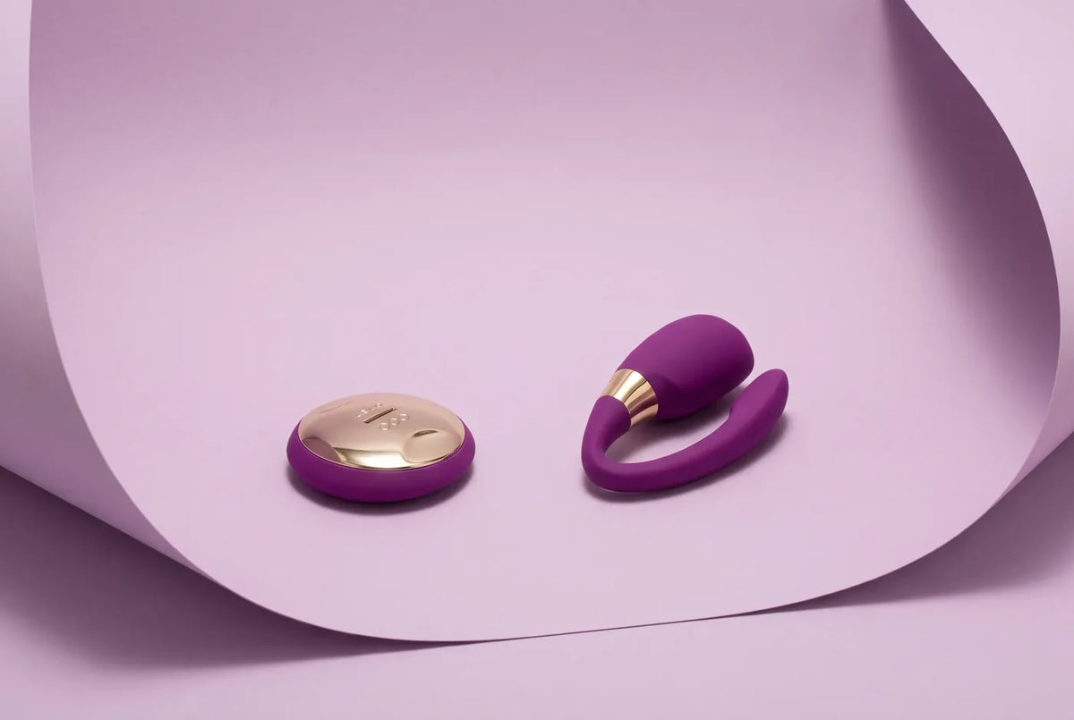 Paarvibrator mit Fernbedienung vor lila Hintergrund.