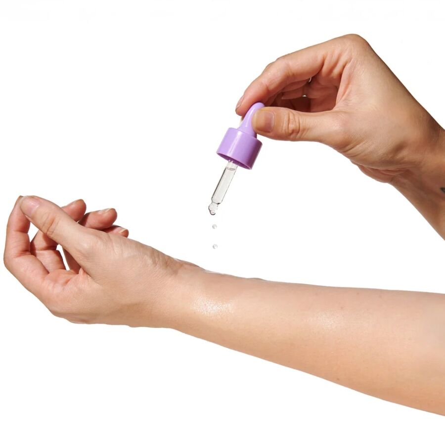 Pipette gibt Lilac-Dream-Öl auf die Innenseite eines Handgelenks