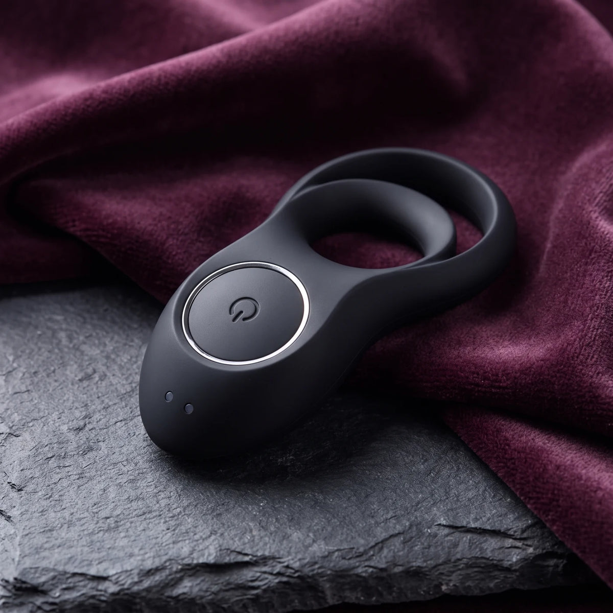 Satisfyer Legendary Duo negro sobre piedra gris oscura.