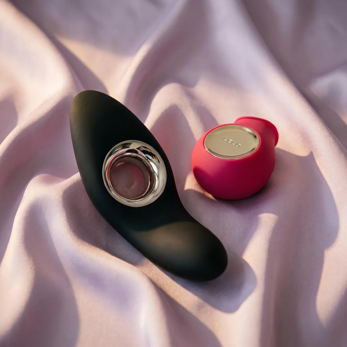 Deux objets de design LELO posés sur du satin lilas.