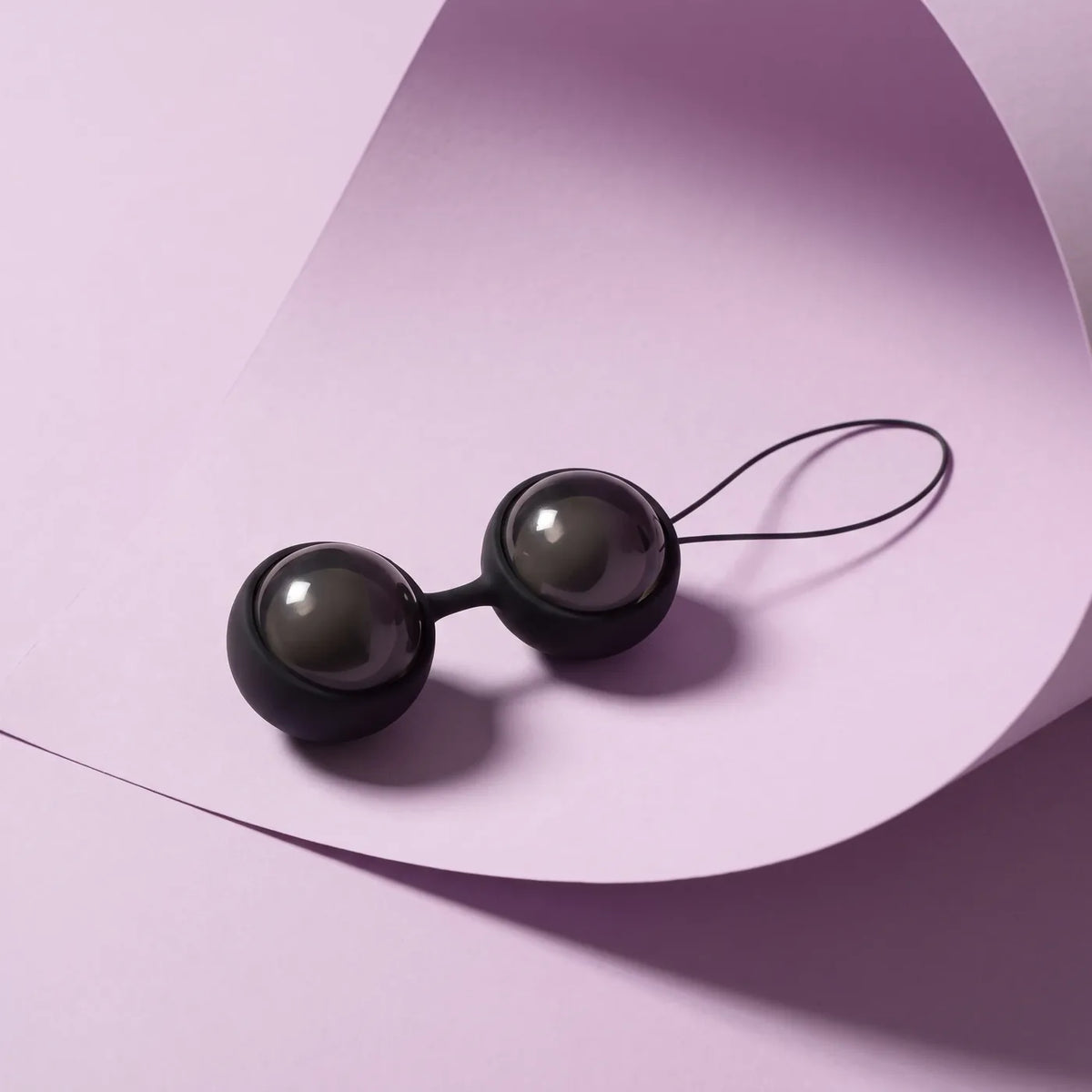 LELO Luna Beads noires sur fond lilas pâle.
