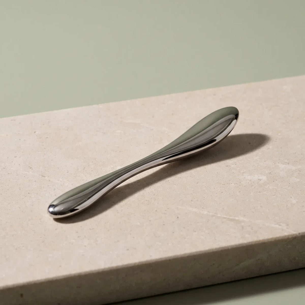Sculpture en acier inoxydable à billes sur pierre claire.