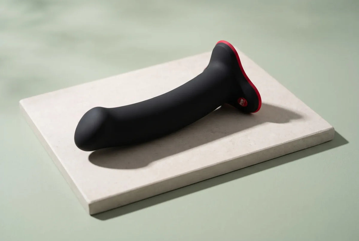 Objets de design en silicone souple posés sur une tablette de pierre claire.