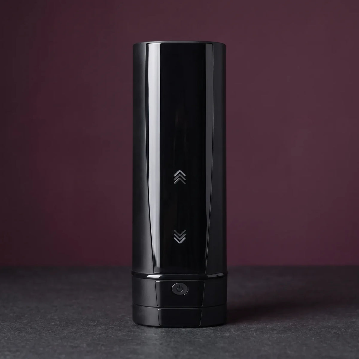 Kiiroo Onyx+ noir posé debout au centre d'une dalle de pierre graphite.