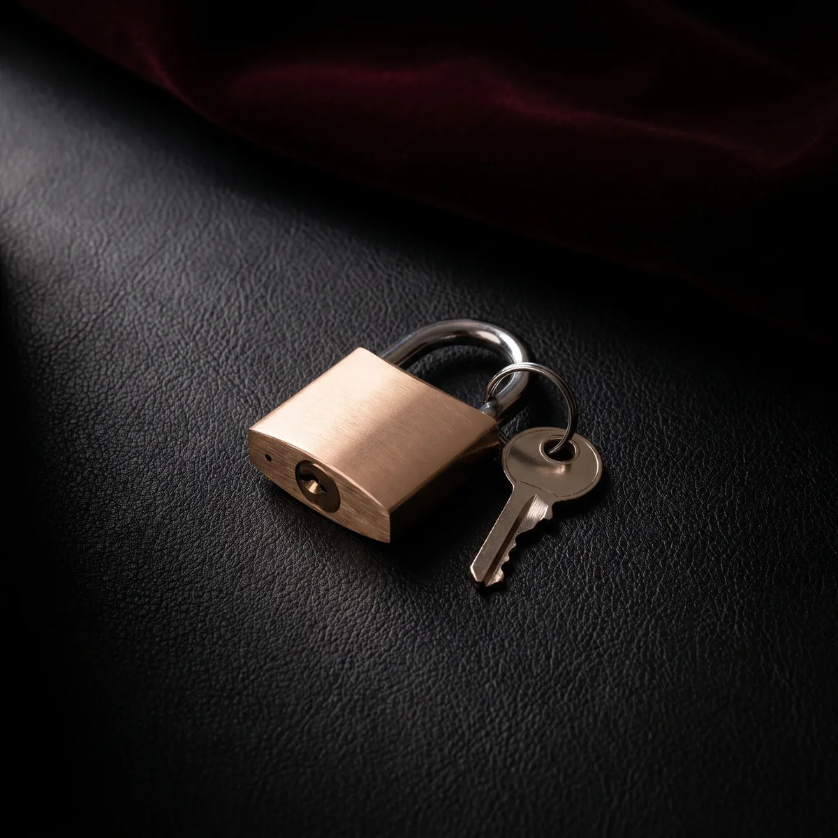 Petit cadenas en laiton et sa clé sur cuir noir.