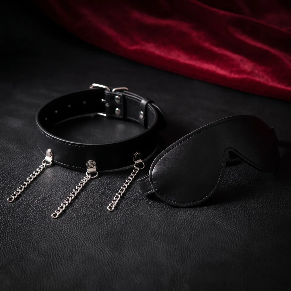 Collier noir à trois chaînes pendantes et bandeau occultant noir sur cuir noir.