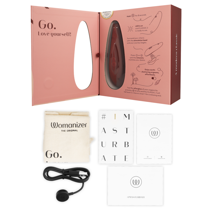 Geöffnete Verpackung des Womanizer Classic 2 mit Beutel, Magnetkabel und Heften